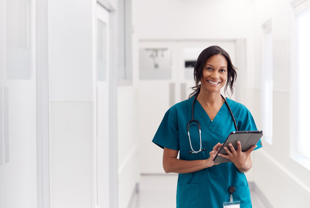 A happy nurse using a Ipad device