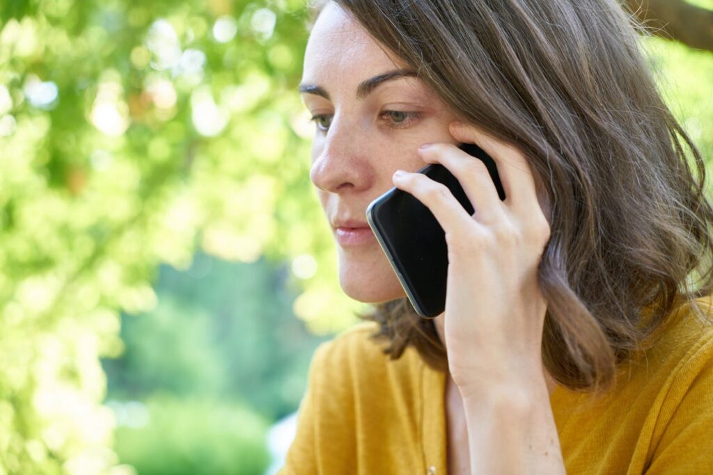 A woman outside using a cell phone